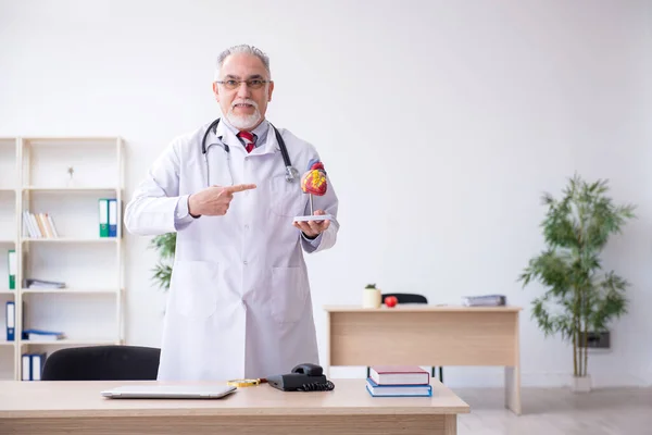 Klinikte çalışan yaşlı bir erkek kardiyolog. — Stok fotoğraf