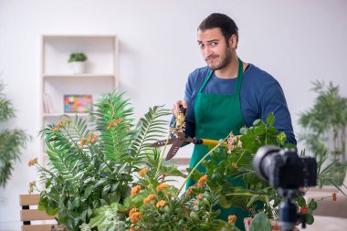 Evin içinde bitkileri olan genç bir erkek bahçıvan.