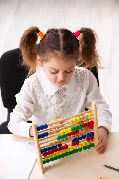 Kleines Mädchen mit Abakus im Klassenzimmer — Stockfoto