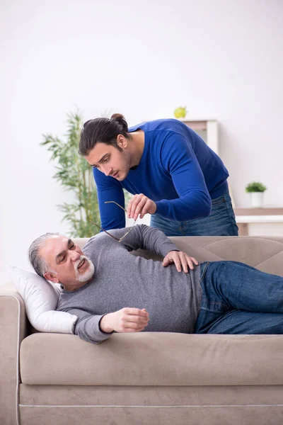 Young man looking after his sick father — Stock Photo, Image