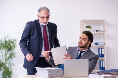 Eski patron ve genç asistanı ofiste çalışıyor.