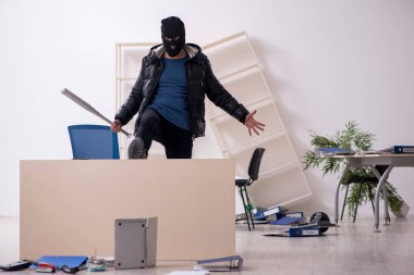 Young male burglar in the office clipart