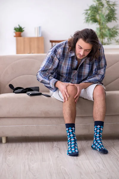 Jovem perna ferido homem sofrendo em casa — Fotografia de Stock