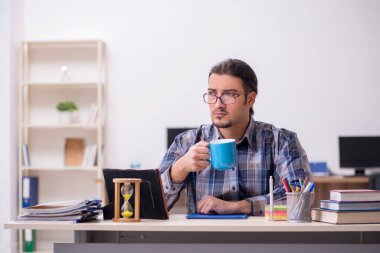 Sınıfta oturan genç erkek öğrenci.