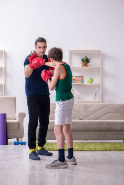 Baba ve oğul içeride spor yapıyor.