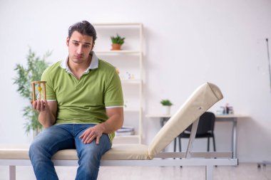 Genç adam klinikte doktor bekliyor.