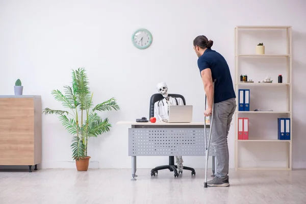 Junger am Bein verletzter Mann besucht toten Arzt — Stockfoto