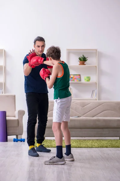 Father and son doing sport exercises indoors