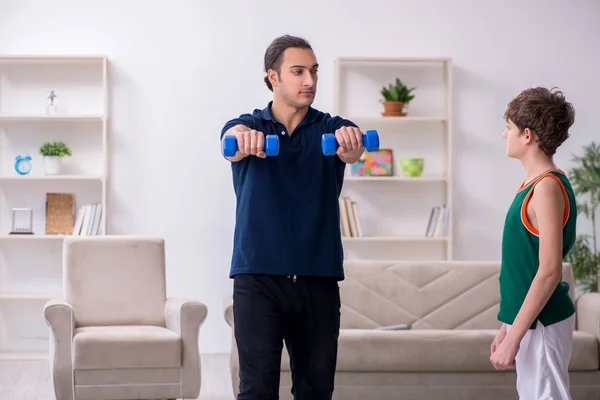 Pai e filho fazendo exercícios esportivos dentro de casa — Fotografia de Stock