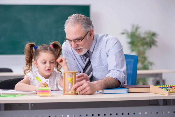 Old teacher and schoolgirl in the school — Stock Photo, Image