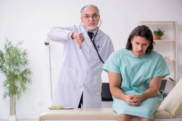 Junge männliche Patientin besucht erfahrenen Arzt — Stockfoto