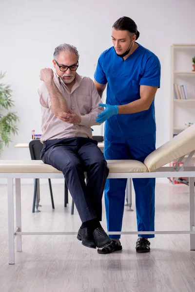 Yaşlı hasta, kan örnekleme konseptiyle genç erkek doktoru ziyaret ediyor. — Stok fotoğraf