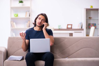 Evden çalışan genç bir adam.