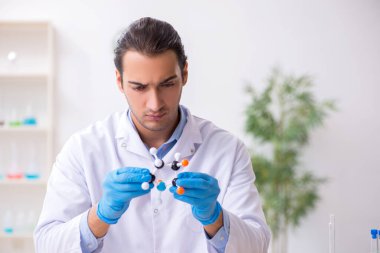 Uyuşturucu sentezi konseptinde genç erkek laboratuvar asistanı