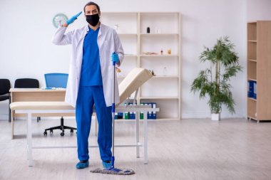 Genç erkek müteahhit salgın konseptinde dezenfekte kliniği