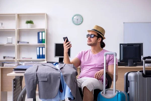 Young male employee preparing for the trip — Stock Photo, Image