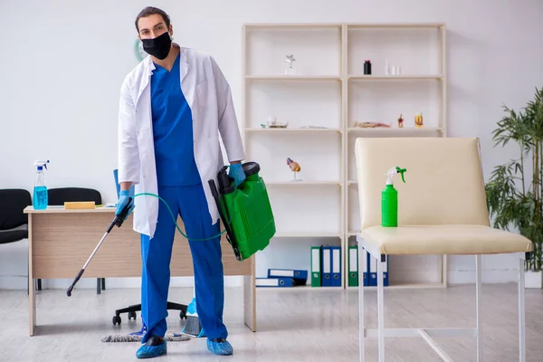 Genç erkek müteahhit salgın konseptinde dezenfekte kliniği