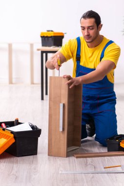 Genç erkek marangoz içeride çalışıyor.