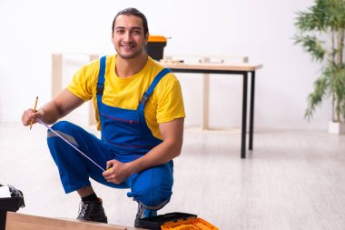 Genç erkek marangoz içeride çalışıyor.