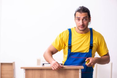 Genç erkek marangoz içeride çalışıyor.