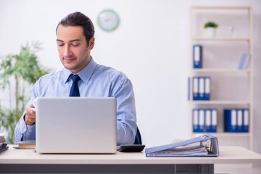 Ofiste genç bir erkek çalışan var.