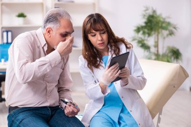 Yaşlı adam estetik ameliyat için genç bayan doktoru ziyaret ediyor.