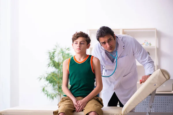 Больной мальчик навещает молодого врача-педиатра — стоковое фото