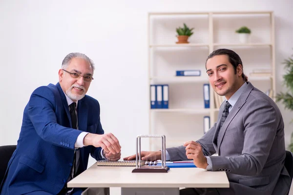 Twee zakenmannen en meditatie ballen op tafel — Stockfoto
