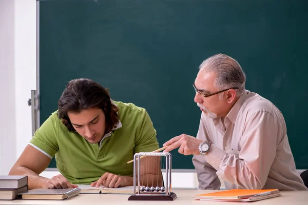 Oude hoogleraar natuurkunde en jonge student in de klas — Stockfoto