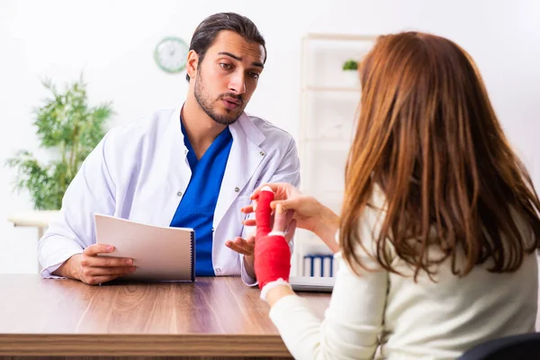 Jovem mão ferida mulher visitando médico traumatologista masculino — Fotografia de Stock