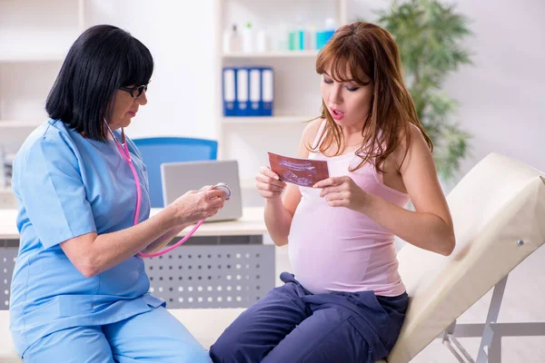 Νεαρή έγκυος γυναίκα που επισκέπτεται έμπειρο γυναικολόγο γιατρό — Φωτογραφία Αρχείου