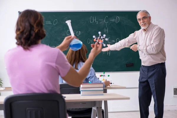 Oude scheikundeleraar en twee leerlingen in de klas — Stockfoto