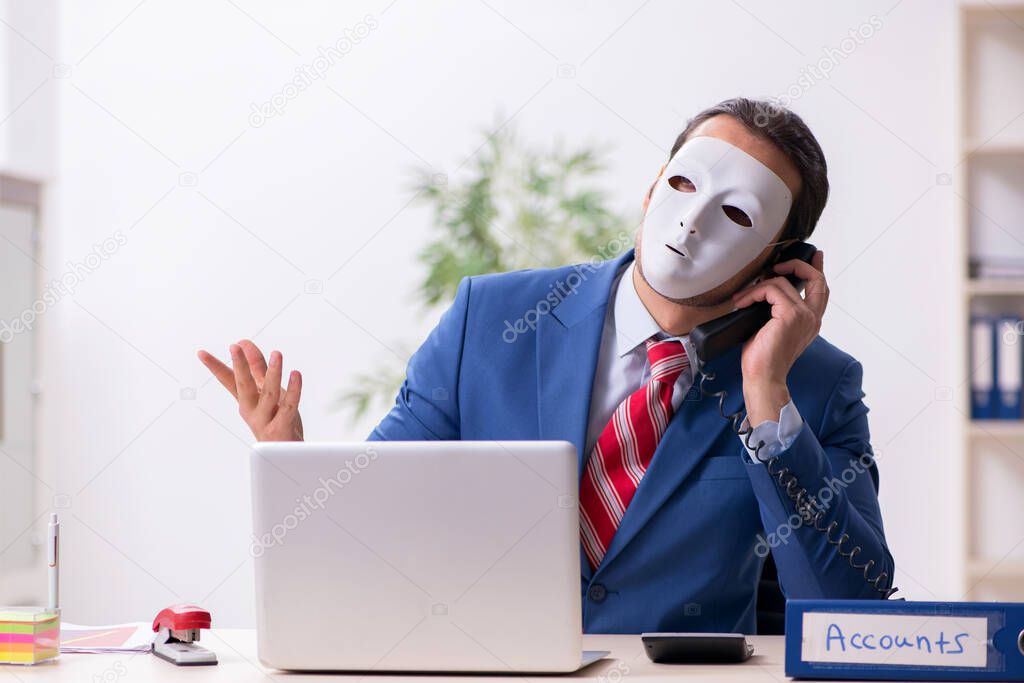 Male employee with mask in hipocrisy concept