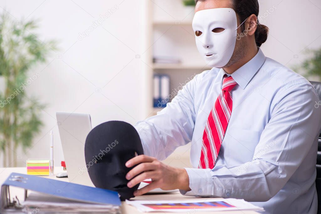 Male employee with mask in hipocrisy concept