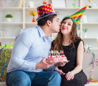 Genç çift doğum gününü pastayla kutluyor.