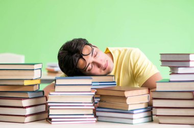 Sınavdan önce okumak için çok fazla kitabı olan öğrenci