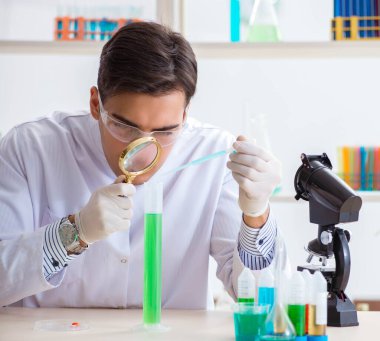Laboratuvarda kimyasallar üzerinde çalışan genç bir kimyager.