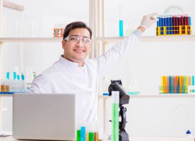 Kimya laboratuvarında deneyler yapan bir erkek öğrenci.