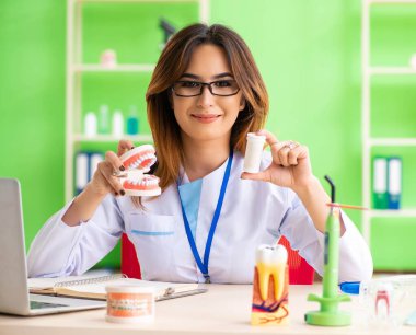 Diş implantı üzerinde çalışan kadın dişçi.