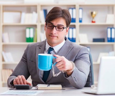 Kahvesine kelepçelenmiş bir iş adamı.