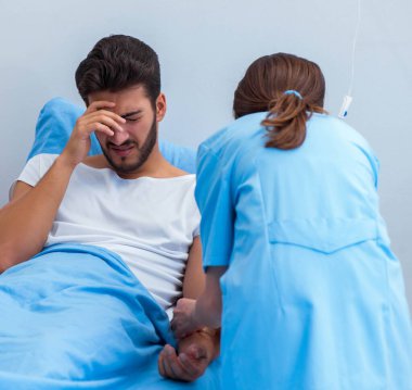 Kadın doktor erkek hastayı hastanede muayene ediyor.
