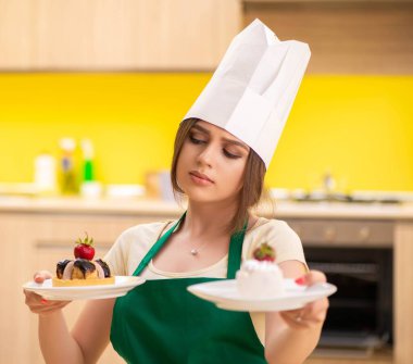 Genç aşçı mutfakta kek pişiriyor.