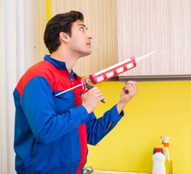 Mutfakta çalışan bir tamirci.