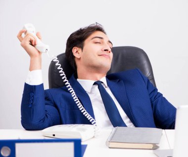 İşadamı ofis telefonundan konuşuyor.