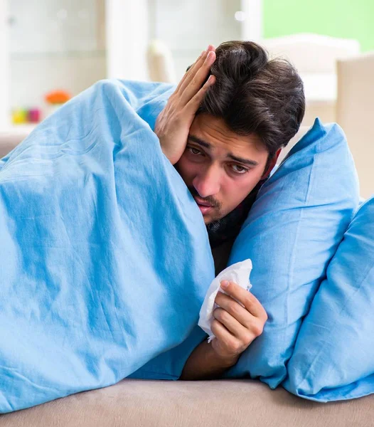 Nemocný mladý muž trpící doma chřipkou — Stock fotografie