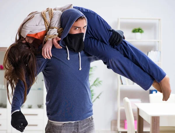 Armed man assaulting young woman at home — Stock Photo, Image