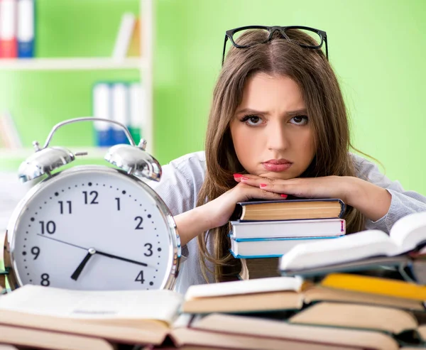 Joven estudiante preparándose para los exámenes con muchos libros a tiempo — Foto de Stock