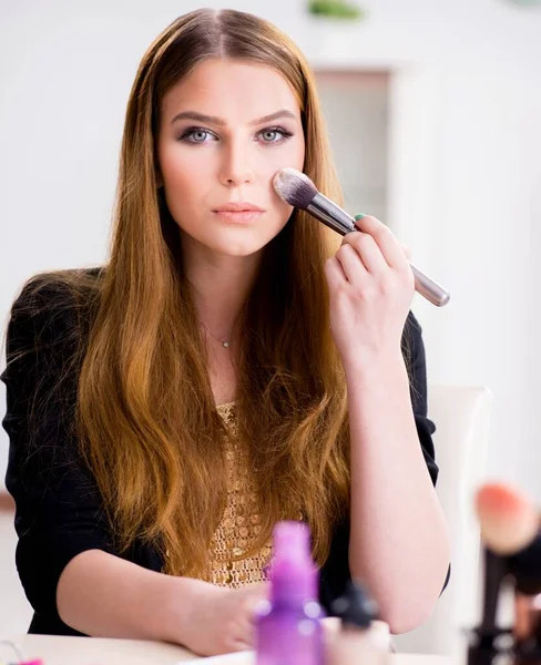 Young woman applying make-up preparing for party — Stock Photo, Image