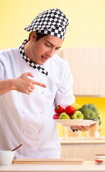 Młody profesjonalny kucharz przygotowuje sałatkę w domu — Zdjęcie stockowe