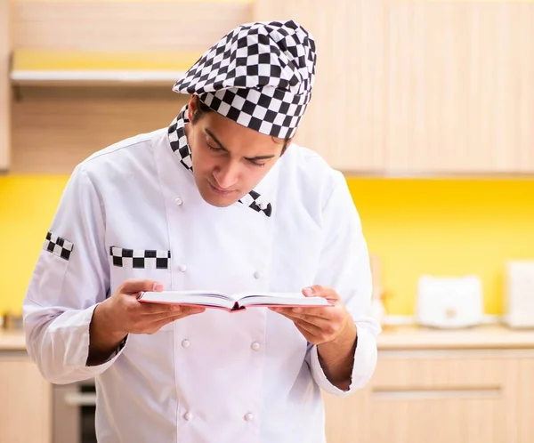 Jovem cozinheiro profissional se preparando na cozinha — Fotografia de Stock